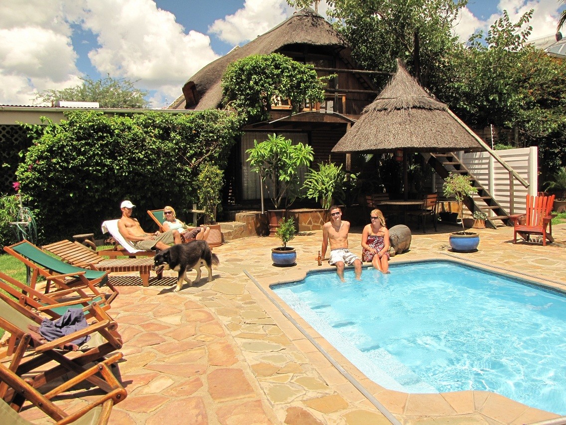 People relaxing at the pool at Chameleon Backpackers hostel