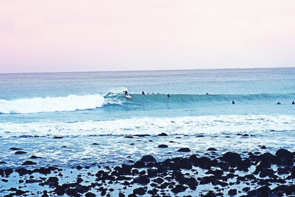 Surfers catching waves at Manu Bay